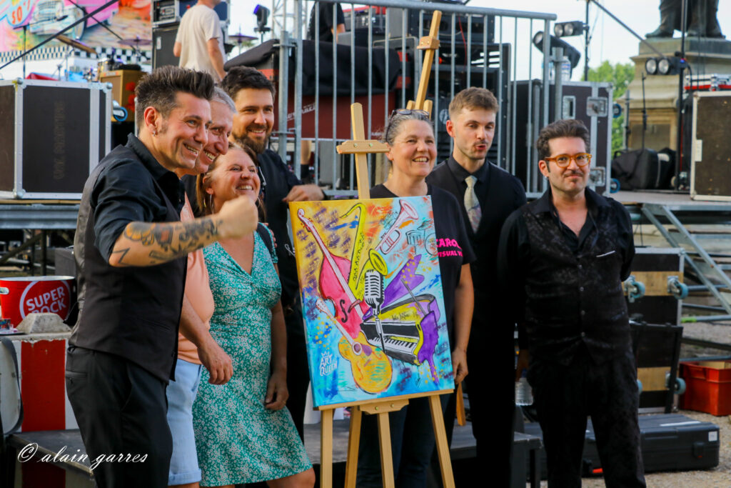 Le groupe The sophisticated cats autour de la toile de live-painting de Carole Tournier