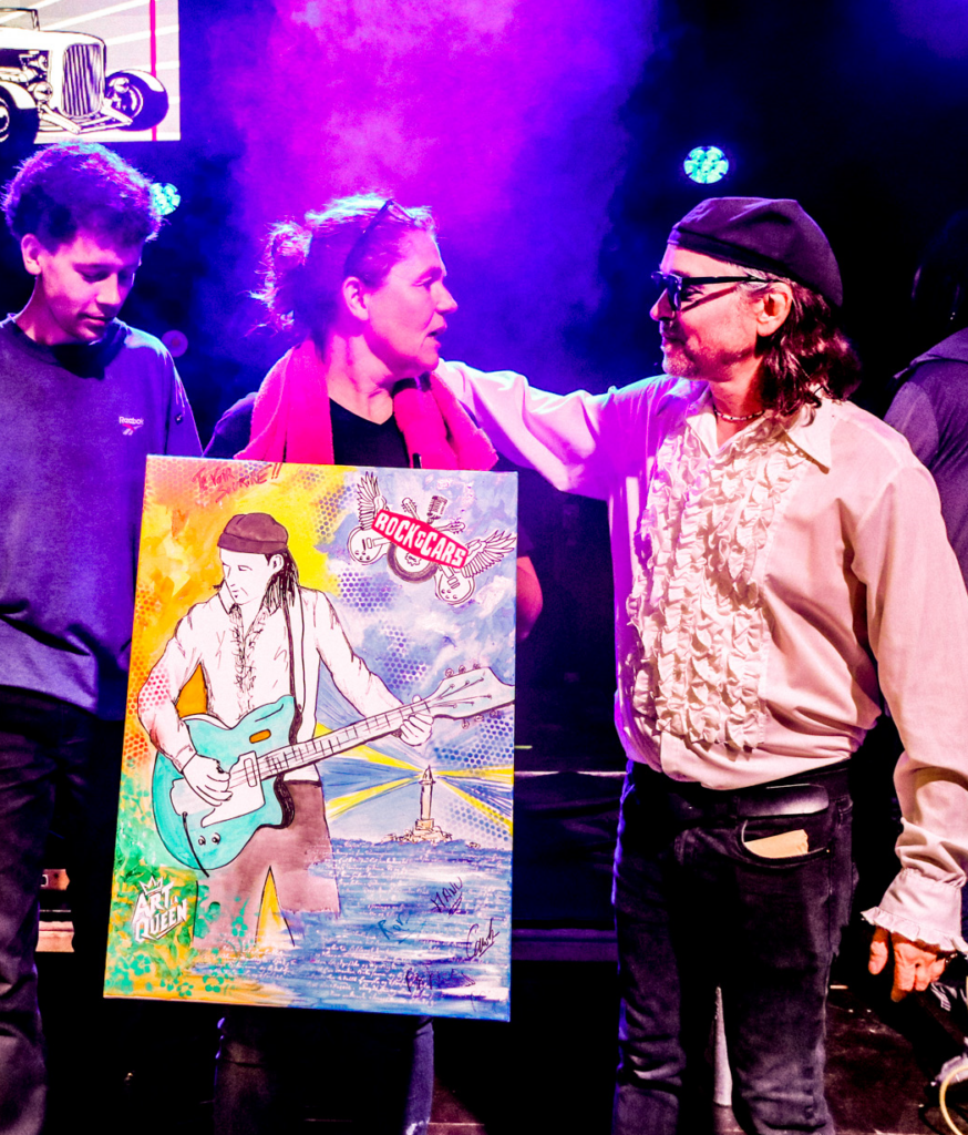 Carole Tournier avec Rod Barthet sur scene du festival apres le live-painting et le tableau signé par les deux artistes.