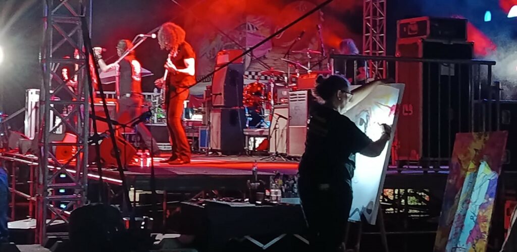 Carole Tournier réalisant un live-painting pendant un concert de the Lords of Altamont au Festival.